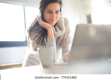 Middle-aged Woman Connected On Internet With Laptop At Home