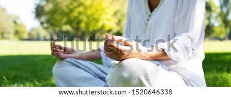 
Middle-aged woman is doing meditation exercises in the park