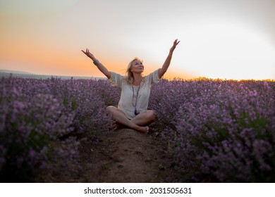 Middle-aged woman dressed boho style clothes, older female breath the healthy air in the field of lavender against the sun - Shutterstock ID 2031505631