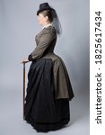 A middle-aged woman dressed in a  Victorian costume from the 1880s