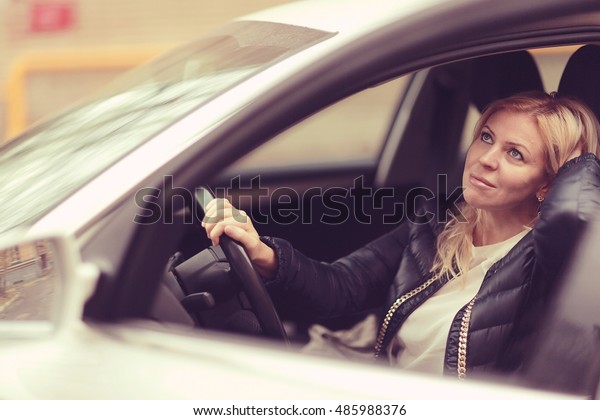 middle-aged woman driver\
at the wheel of car