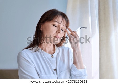 Middle-aged woman experiencing stress, difficulties, headache