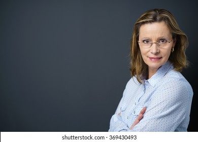 Middle-aged Woman With Folded Arms Looking Over Her Shoulder At The Camera, With Copy-space