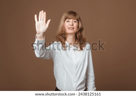 Middle-Aged Woman Greeting or Waving Goodbye. Friendly and Attractive Lady in Her Prime Waving with a Warm Smile, Extending Greetings or Bidding Farewell to Friends