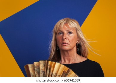 Middle-Aged Woman Having A Hot Flash, Holding A Fan