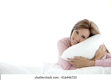 Middle-aged Woman Holding A Pillow On A Bed