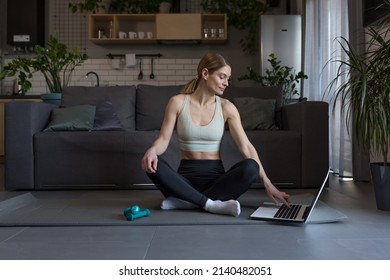 A Middle-aged Woman At Home, Engaged In Fitness And Fog, Uses A Laptop For Online Group Activities