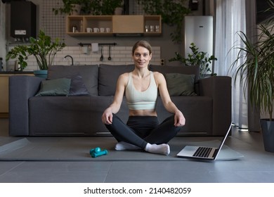 A Middle-aged Woman At Home, Engaged In Fitness And Fog, Uses A Laptop For Online Group Activities