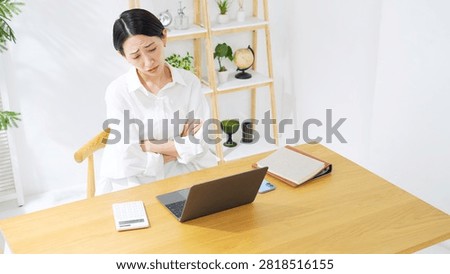 A middle-aged woman looking dejected while looking at her laptop. Dissatisfaction, questions, worry, trouble, work, complaints, grumbling, failure, regret.