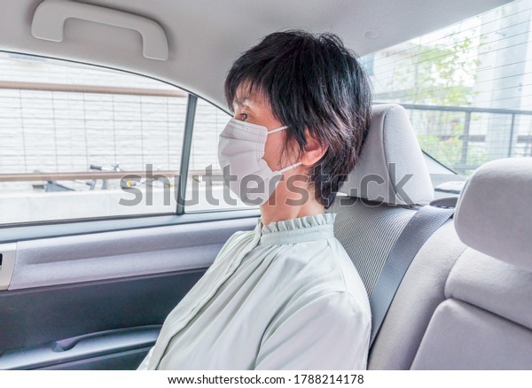 middle-aged woman with\
mask in a car in\
Japan
