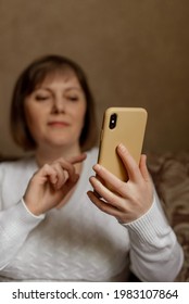 A Middle-aged Woman With A Phone In Her Hands, Always In Touch, Checking Social Networks, Video Calling, Working On The Phone, Copy Space, Negative Space