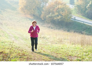 Middle-aged Woman Running Through The Woods