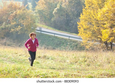 Middle-aged Woman Running Through The Woods