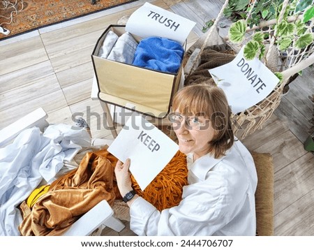 Middle-Aged Woman Sorting Belongings With KonMari Method. Mature woman categorizes items into keep and discard piles