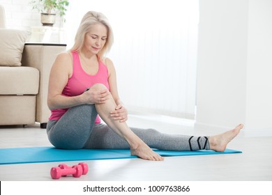 Middle-aged woman suffering from pain in leg at home, closeup. Physical injury concept. - Shutterstock ID 1009763866