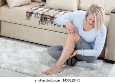 Middle-aged Woman Suffering From Pain In Leg At Home, Closeup. Physical Injury Concept. Ankle Pain, Painful Point.