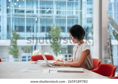 Middle-aged woman using computer technology for financial marketing work online. Busy mature Asian professional businesswoman analyst working concentrated on laptop pc at desk in office. Copy space