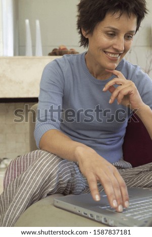 Similar – Young female sitting by table and making clay or ceramic mug in her working studio