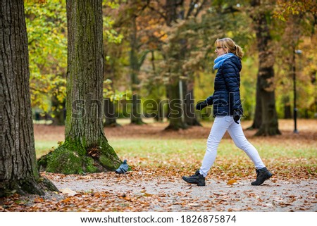 Middle-aged woman walking in city park 