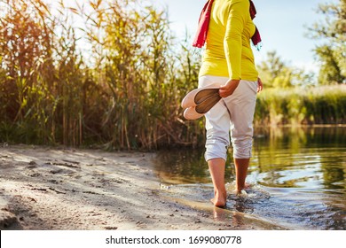 Middle-aged Woman Walking On River Bank On Spring Day. Senior Lady Having Fun In The Forest Enjoying Nature.