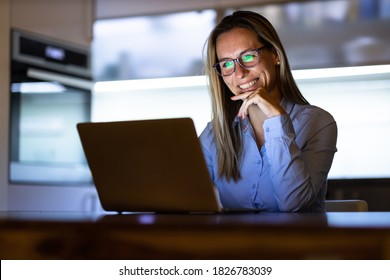 Middle-aged Woman Working Late In The Day On A Laptop Computer At Home, Running A Business From Home/working Remotely For A Corporation