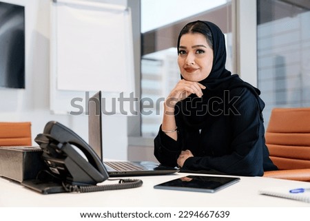 Middle-eastern businesswoman wearing traditional arab abaya working in the office in Dubai - Adult arabian corporate business woman working in the UAE