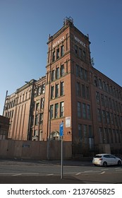 MIDDLETON, UK - March 21, 2022: An Old Victorian Red Brick Cotton Mill In Bright Sunlight