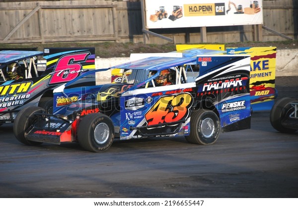 Middletown, NY, USA - April 2,\
2022: Champion short track racer Jimmy Horton steers his Dirt\
Modified stock car toward the green flag at Orange County Fair\
Speedway.