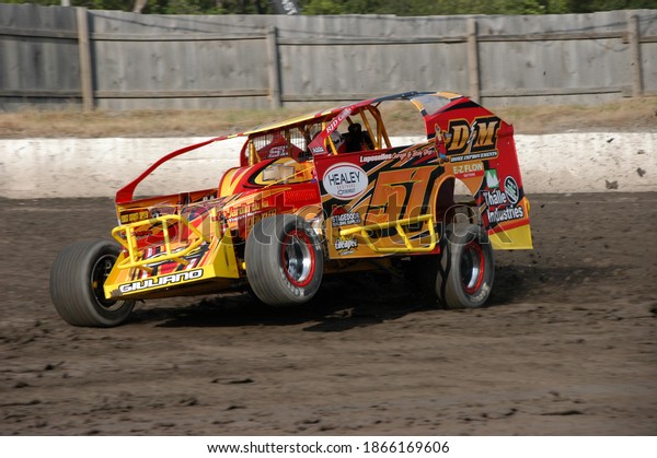 Middletown, NY, USA - June 20,\
2020: Short track racer Mike Giuliano hustles his Dirt Modified\
stock car around a rough dirt track at Orange County Fair Speedway.\
 