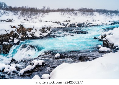 Midfoss Waterfall. The 'Iceland’s Bluest Waterfall.' Blue water flows over stones. Winter Iceland. Visit Iceland. Hiking to bruarfoss waterfall