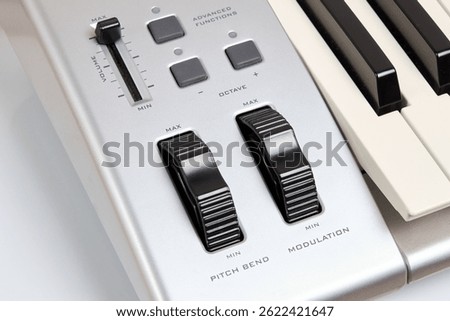Midi keyboard controller close up with faders wheel buttons and knobs pitch, band, modulation, octave max min