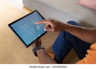 Midsection of african american man using tablet with weather forecast. Spending quality time at home alone. - Powered by Shutterstock