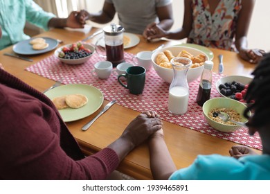 Midsection Of African American Parents, Son And Grandparents Holding Hands In Prayer At Dinner Table. Three Generation Family Spending Quality Time Together.