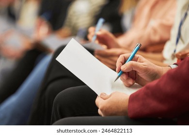 Midsection of audience writing in document during business conference at convention center