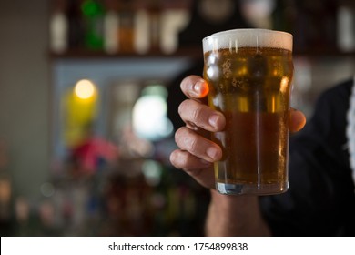 Mid-section Of Bar Tender Offering Beer