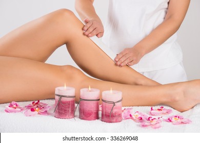 Midsection Of Beautician Waxing Woman's Leg At Salon