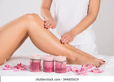 Midsection Of Beautician Waxing Woman's Leg At Salon