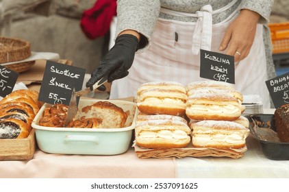 Midsection body of a baker at a stand at the farmers market selecting a sweet pastry for a customer - Powered by Shutterstock