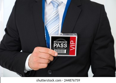 Midsection Of Businessman With Backstage Pass In Office