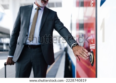Midsection of businessman pushing open door button of subway train. Senior male professional is standing at station platform. He is wearing suit during business travel.