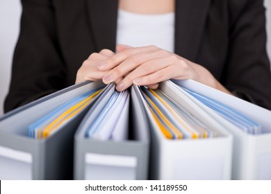Midsection of businesswoman with binders at office