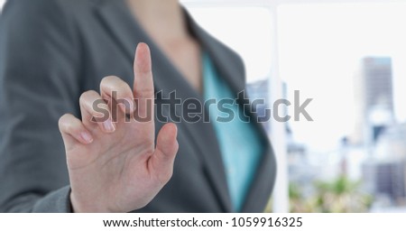 Midsection of businesswoman touching imaginary screen