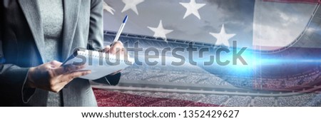Midsection of businesswoman writing on note pad against close-up of an american flag
