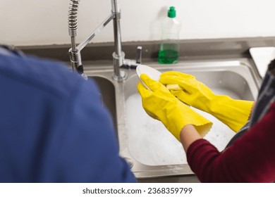 Midsection of diverse couple doing dishes in kitchen at home. Lifestyle, togetherness, relationship, cleaning and domestic life. - Powered by Shutterstock