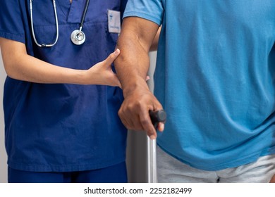 Midsection of diverse female doctor helping senior male patient use walking stick, copy space. Hospital, medical and healthcare services. - Powered by Shutterstock