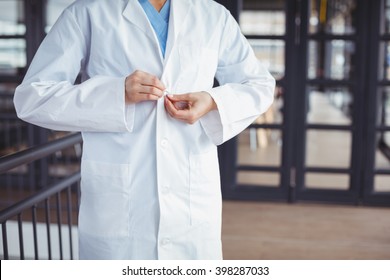 Midsection of doctor wearing lab coat while standing at hospital - Powered by Shutterstock