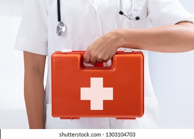 Mid-section Of A Doctor's Hand Holding Red First Aid Bag On White Background - Shutterstock ID 1303104703