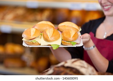 Midsection Of Female Coffee Shop Worker Holding Tray Full Of Burgers