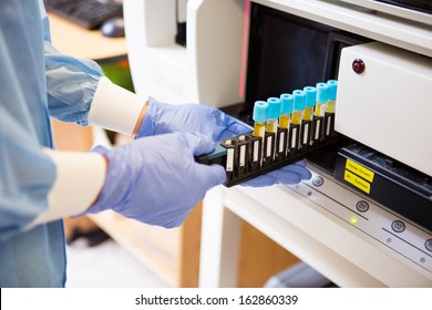 Midsection Of Female Lab Tech Loading Specimen For Coagulation Test Analysis