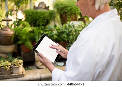 Midsection of female scientist using tablet computer at greenhouse - Powered by Shutterstock